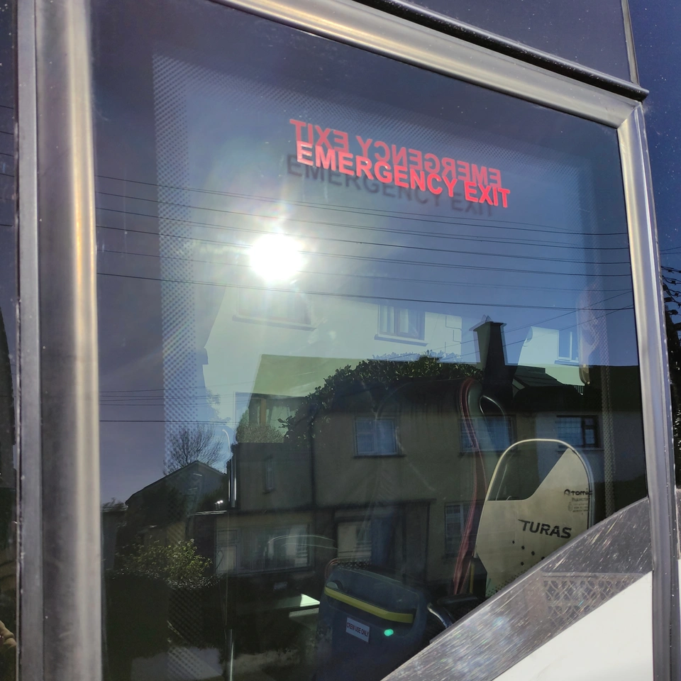 Coach side window after restoration, with reflections visible across the glass.